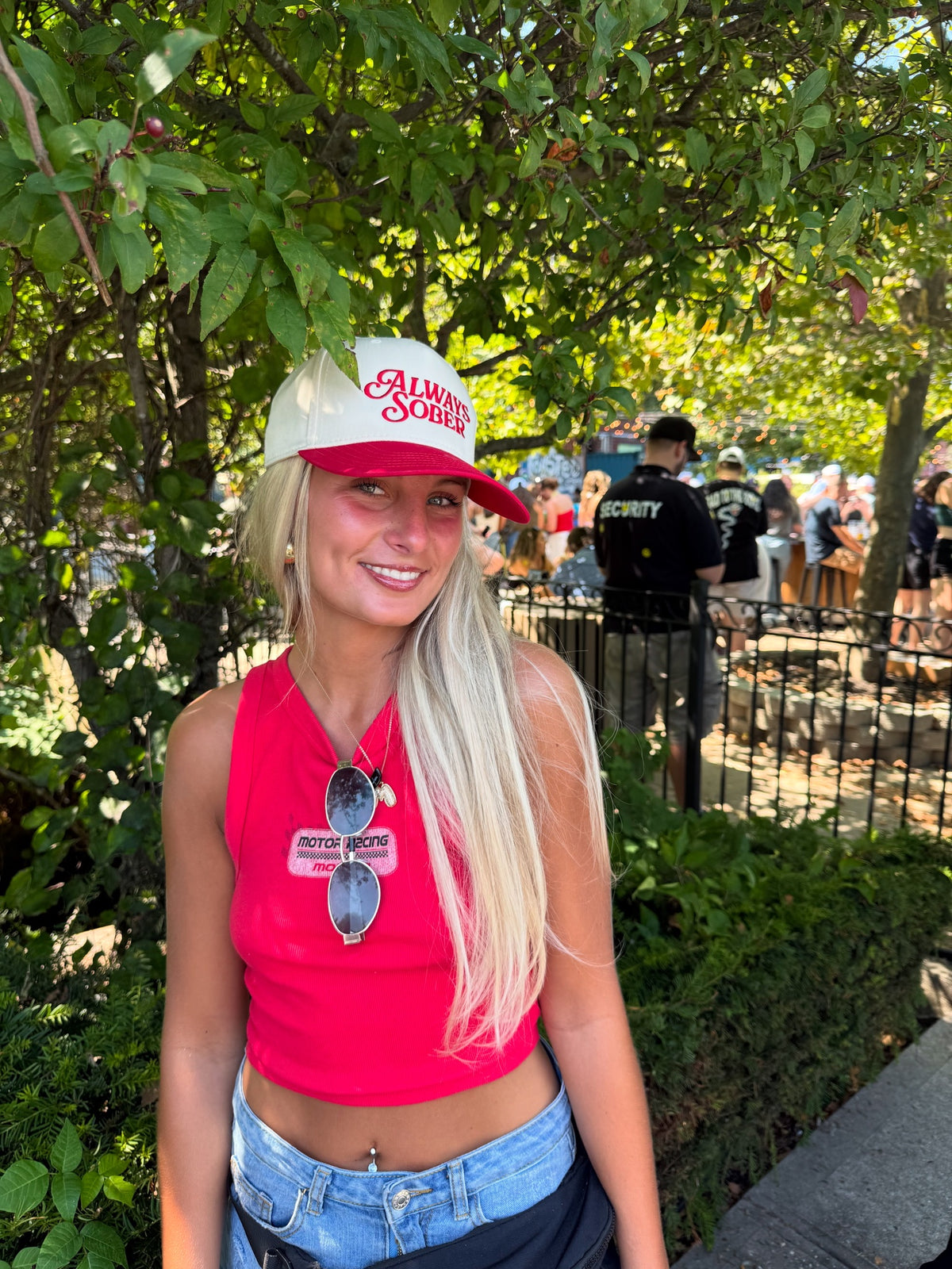 a bone colored hat with red writing and a red brim 